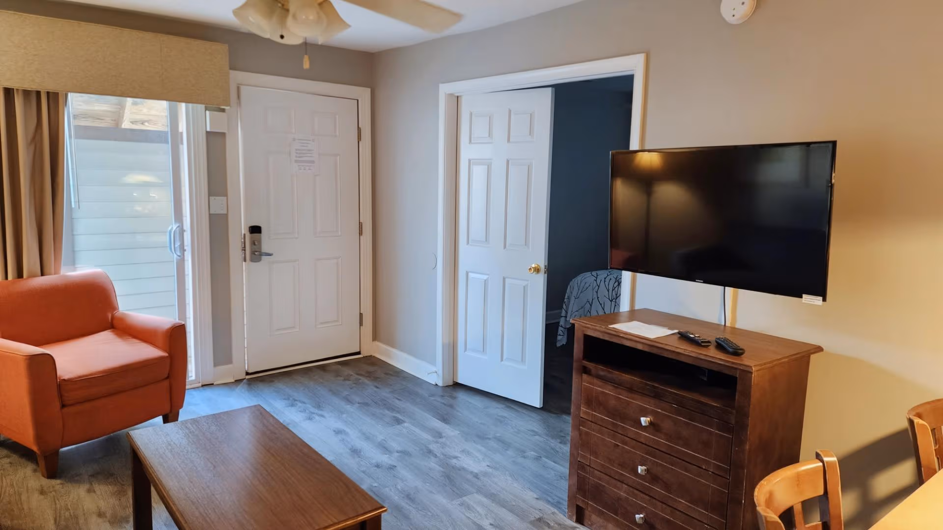 Living area with armchairs, sofa, and sliding glass doors