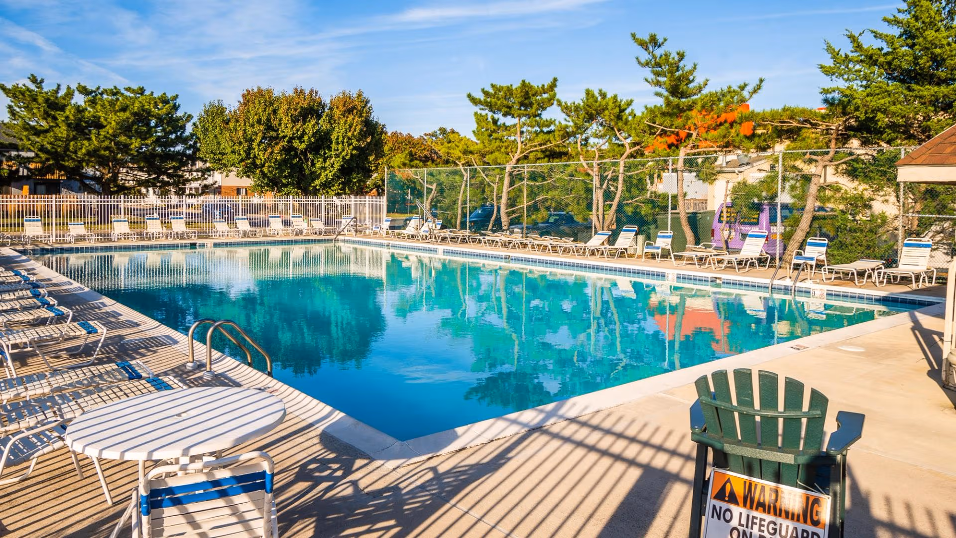 Resort pool area with umbrellas, seating, and landscaped surroundings