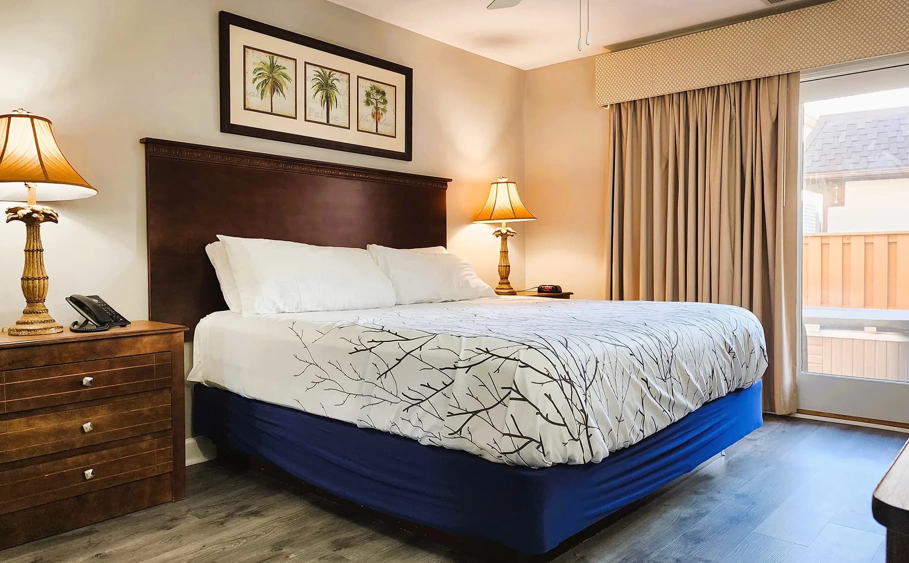 Cozy bedroom with king-size bed, warm lighting, and a balcony view.